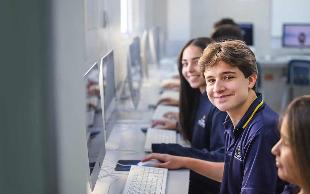 talentoso joven-sonriendo-a-la-camara-en-laboratorio-de-clases-lux-mundi
